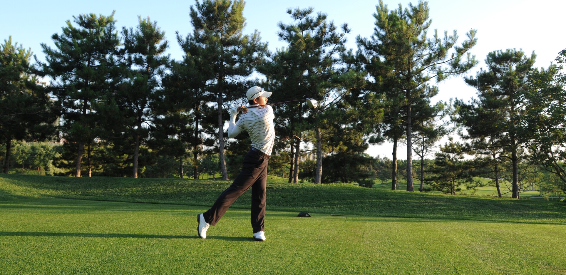 golfer taking a swing on golf course