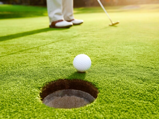 Golf ball near golf course hole