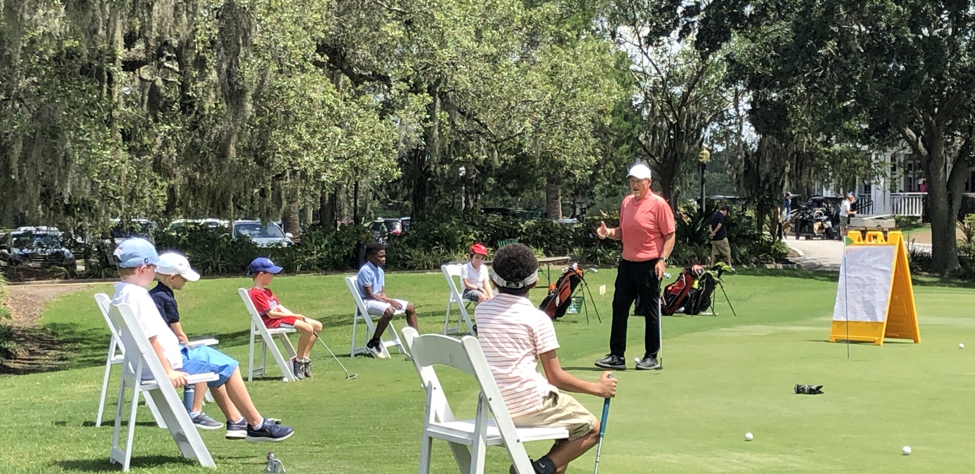 Instructor teaching junior golfers on golf course