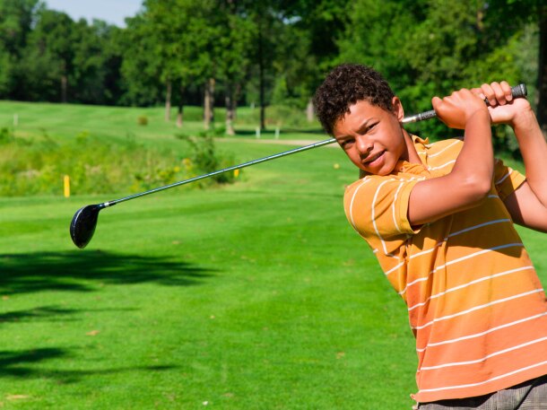 Junior Golfer taking a swing on golf course