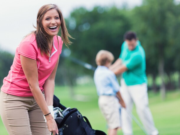 Golfer on golf course with instructor teaching in background